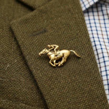 Gold horse brooch on a brown jacket with a checkered shirt underneath